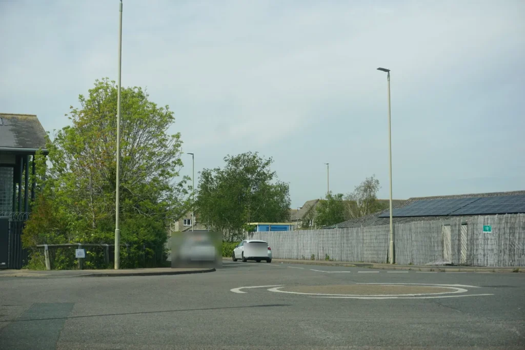Painted white mini roundabout circle with give way markings at a junction on a business park road